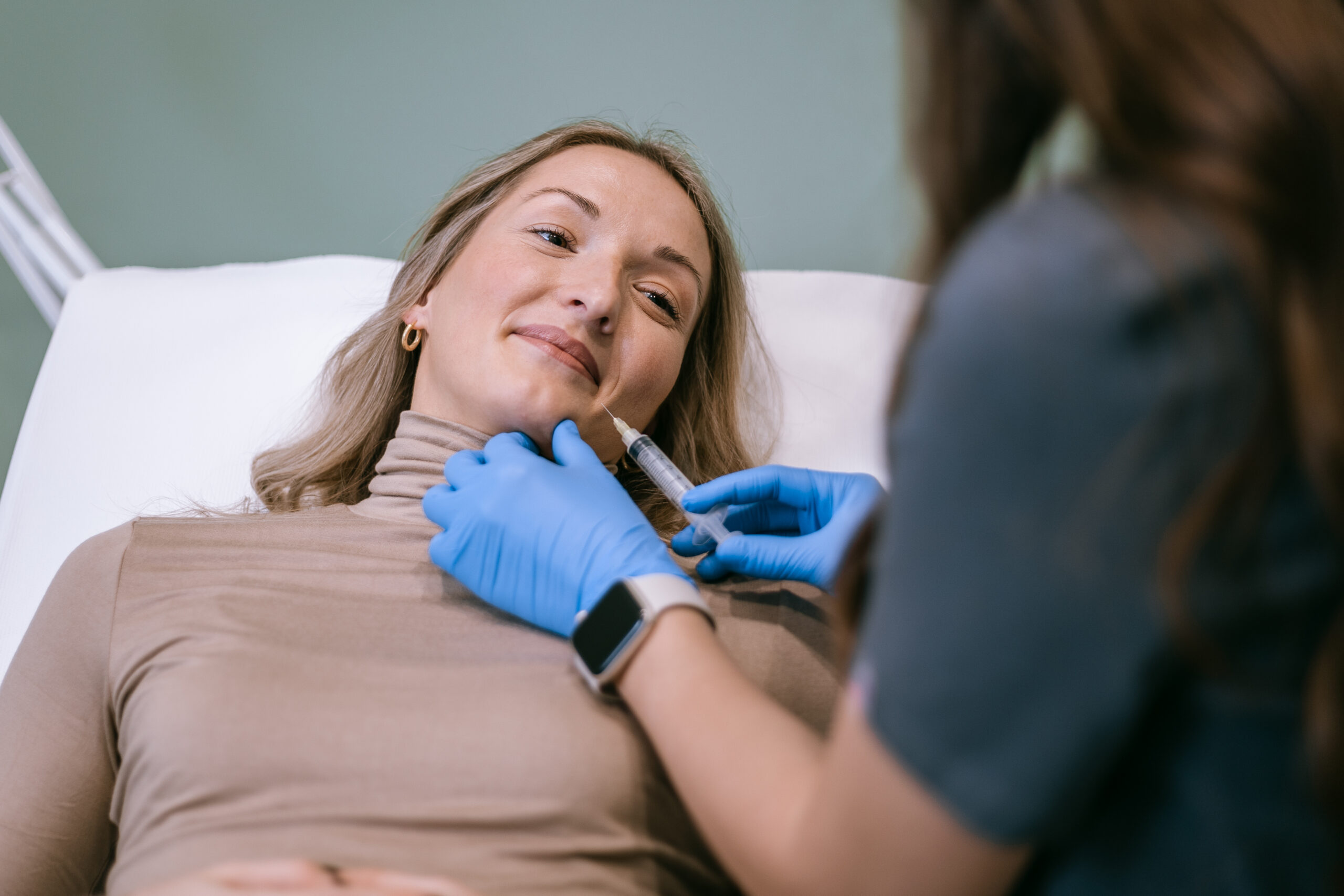 doktorica radi botox na pacijentu i drzi iglu